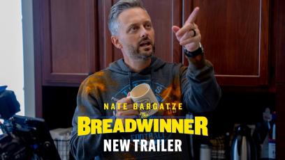 Nate-Bargatze-in-a-kitchen-pointing-while-holding-a-mug-and-wearing-a-dirty-hoodie